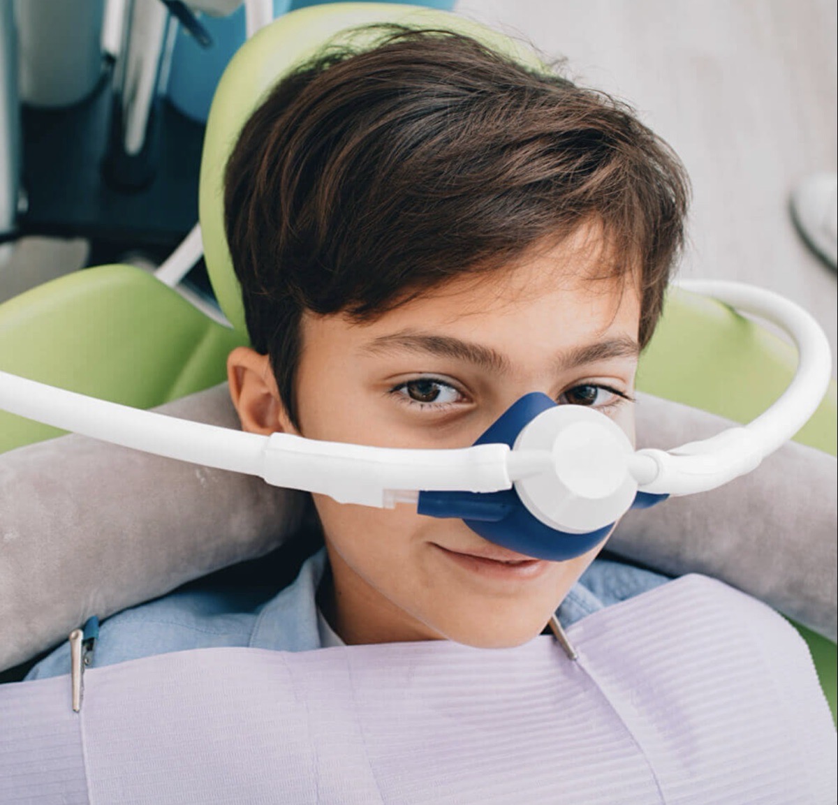 Relaxed young patient resting in the dental chair with a nitrous oxide nasal mask